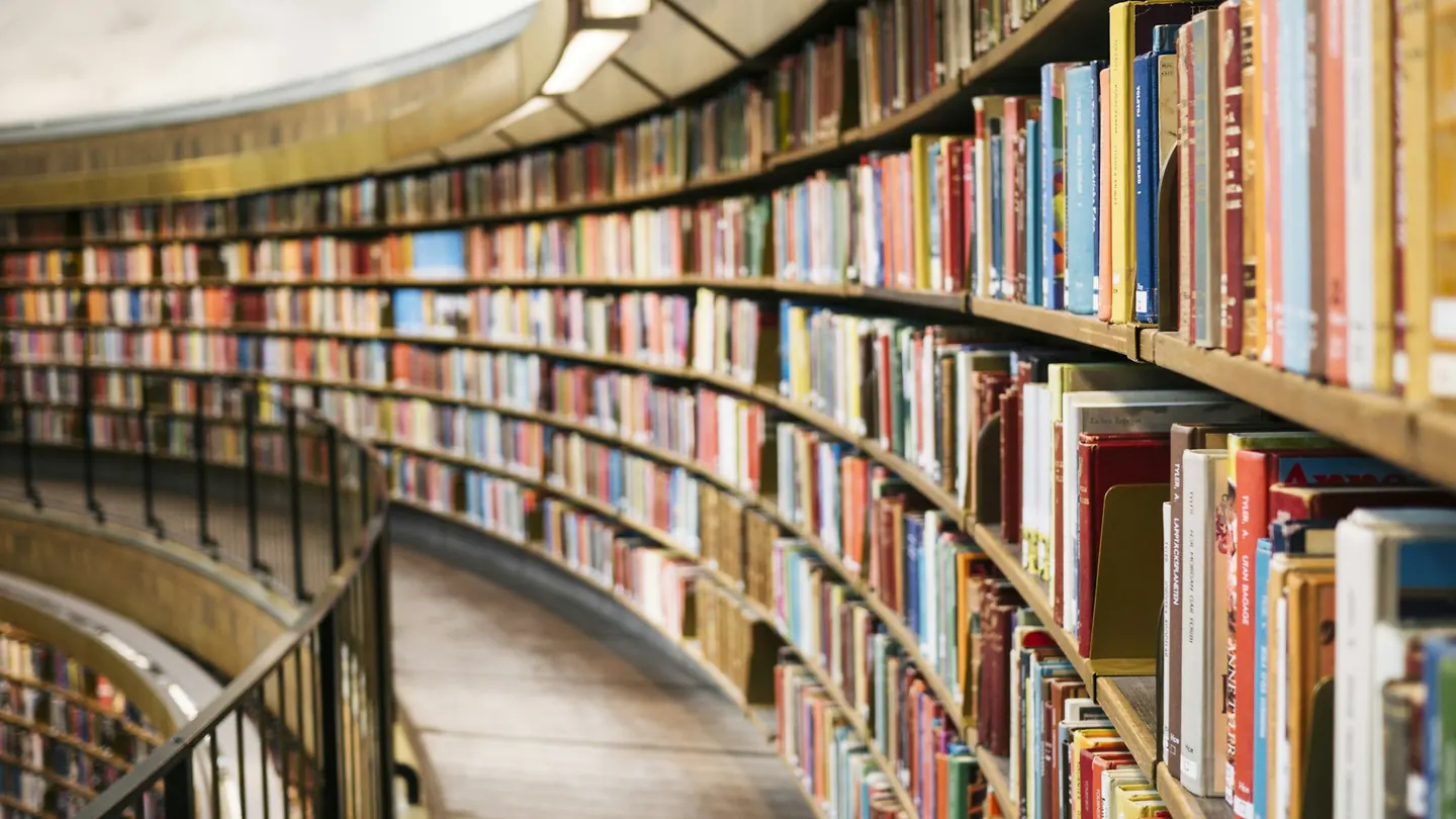 A curved wall of bookshelves in a library